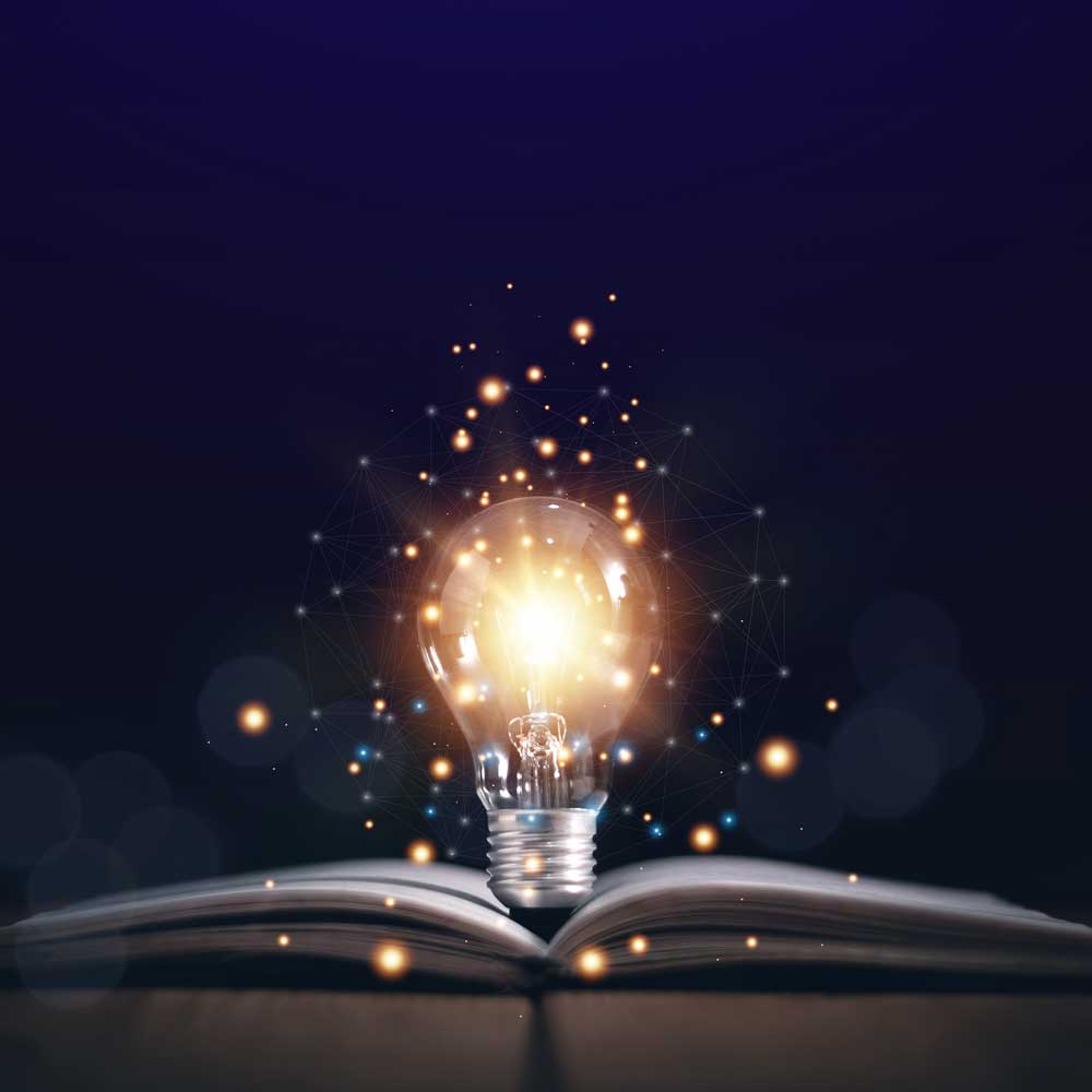 A glowing light bulb emits bright, warm light while floating above an open book. Small particles of light and interconnected lines surround the bulb, creating a magical and innovative atmosphere against a dark background, reminiscent of an improv stage transforming into a social therapeutic space.